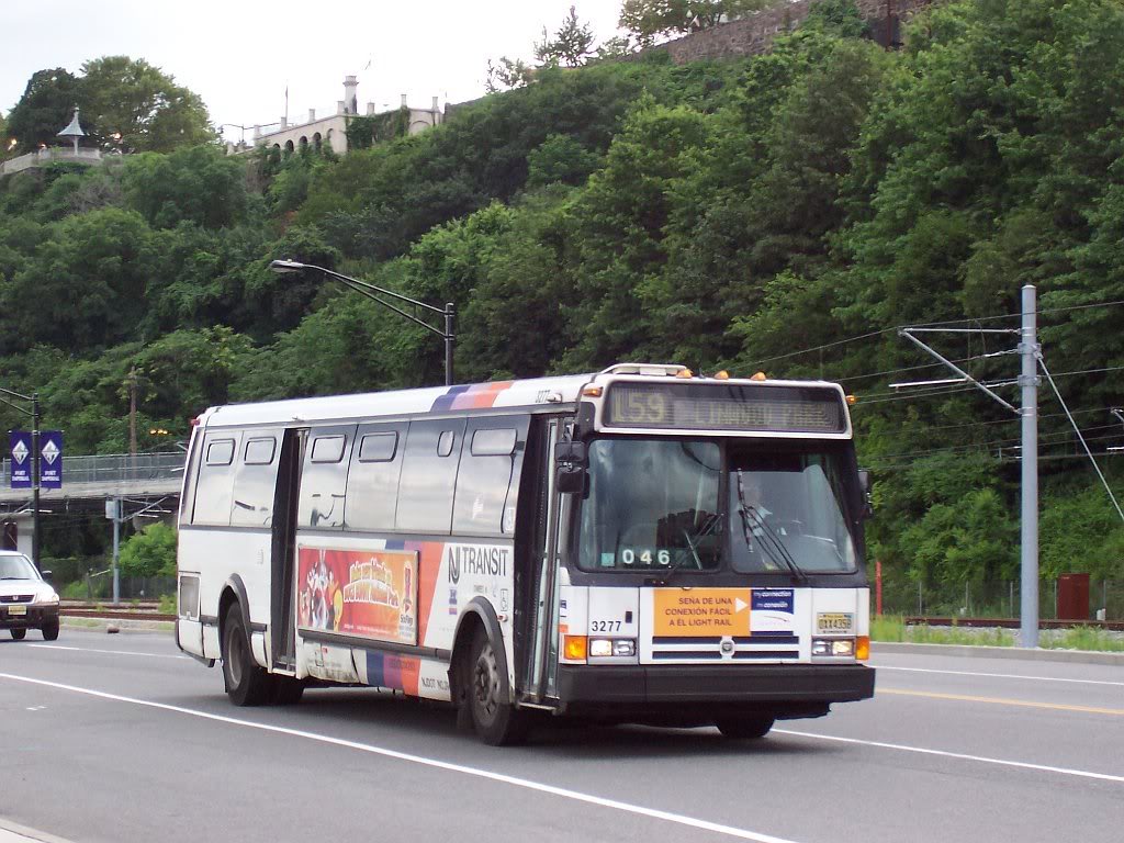 A Transit Bus With the Number 159 on the Front, Driving on a Road With a Green Hill